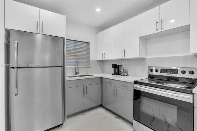 a kitchen with stainless steel appliances white cabinets and a refrigerator