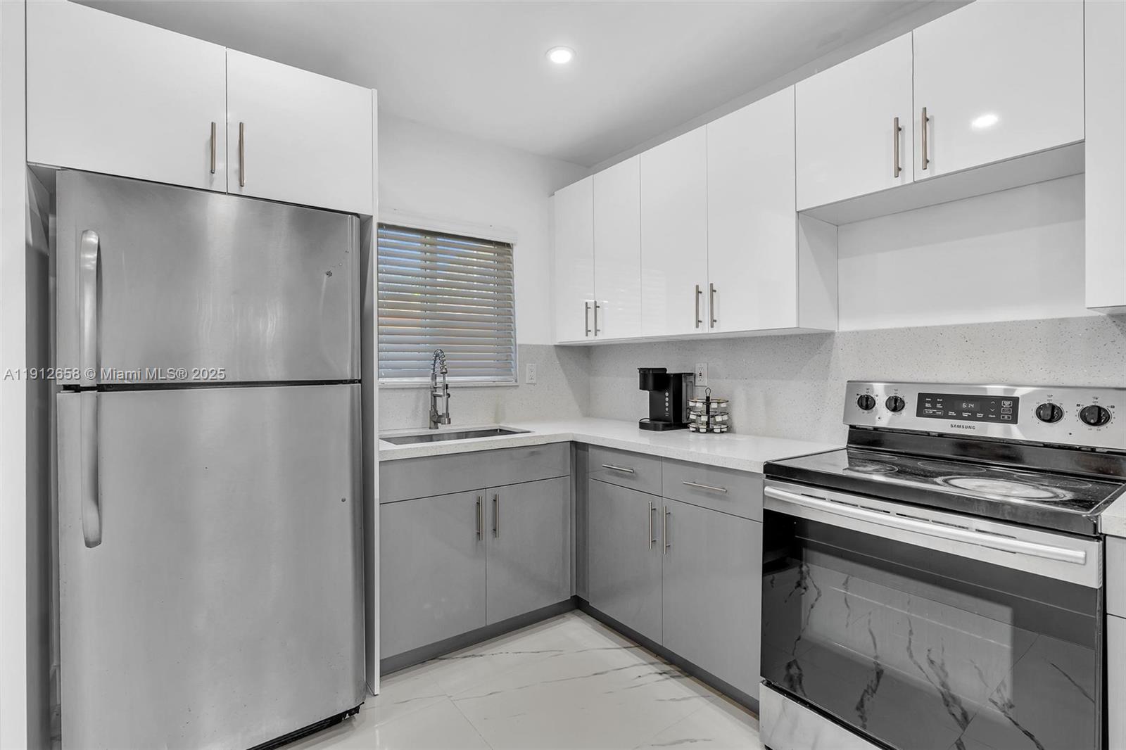 797 Northwest 35th Street Miami, FL 33127 - Photo 15 of 45 a kitchen with stainless steel appliances white cabinets and a refrigerator