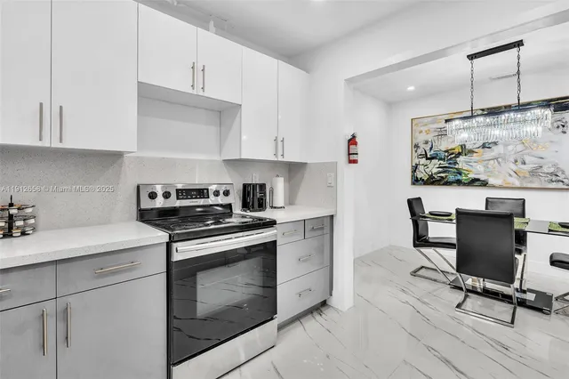 a kitchen with stainless steel appliances white cabinets and a stove top oven