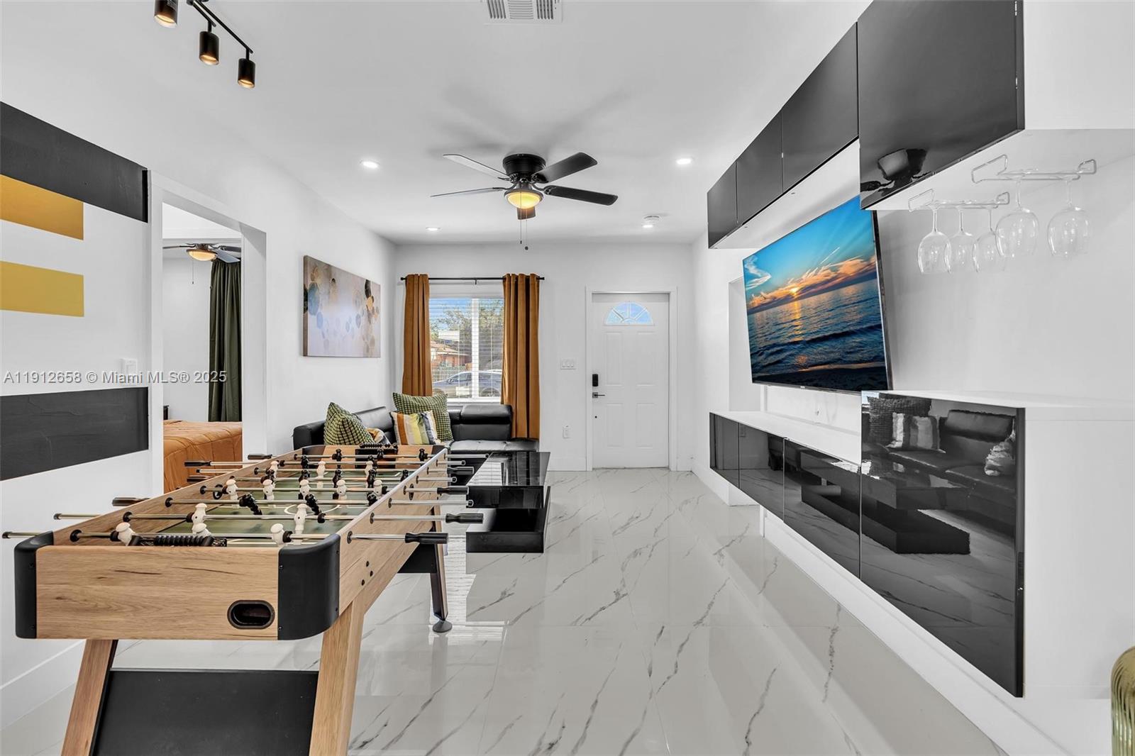 797 Northwest 35th Street Miami, FL 33127 - Photo 25 of 45 a living room with furniture a flat screen tv and kitchen view