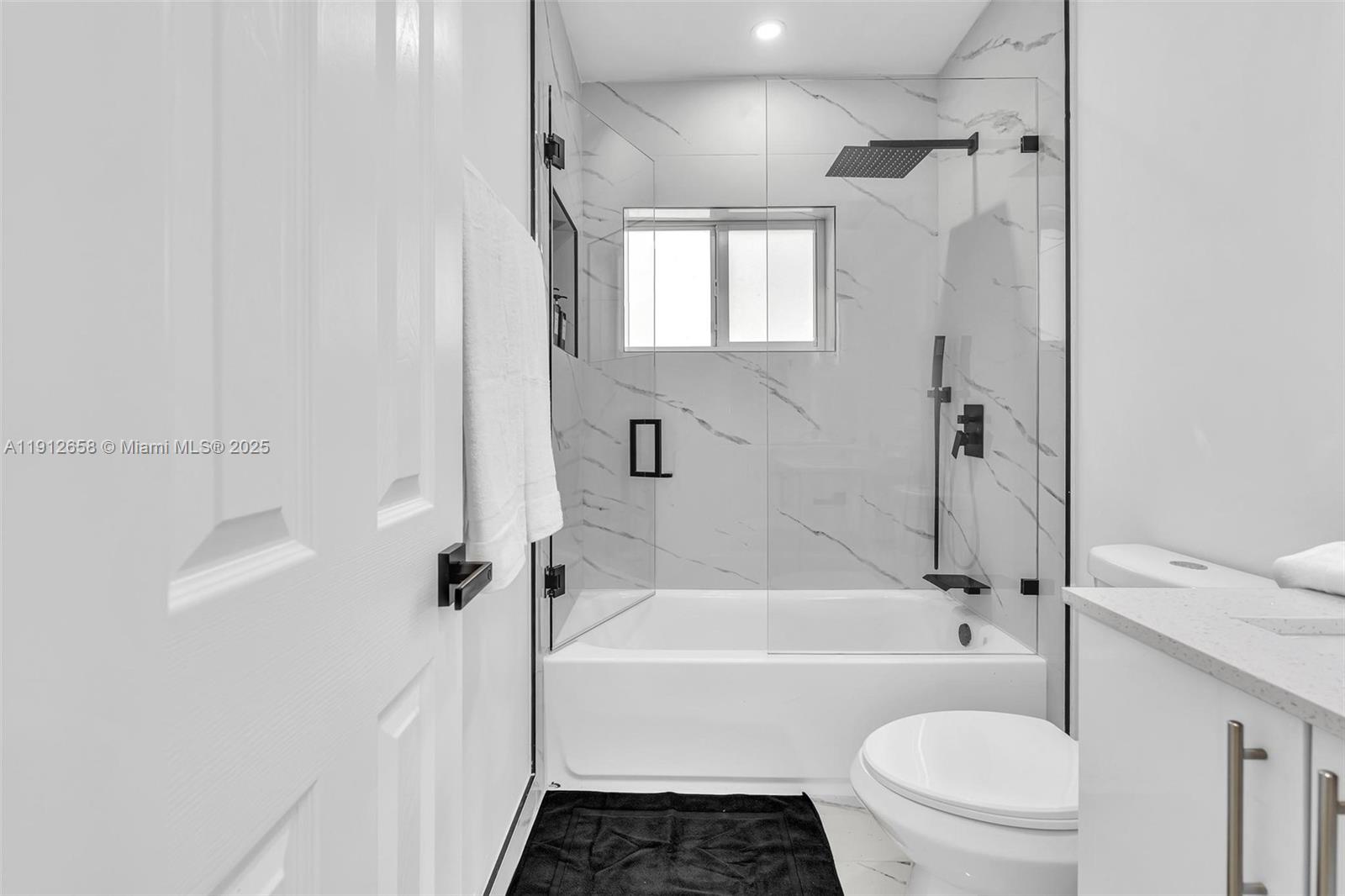 797 Northwest 35th Street Miami, FL 33127 - Photo 29 of 45 a bathroom with a granite countertop bathtub shower sink vanity and toilet