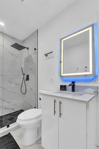 a bathroom with a granite countertop toilet sink and mirror