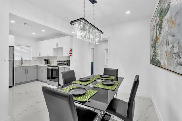 a kitchen with a dining table chairs and stainless steel appliances