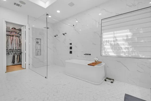 a bathroom with a tub a sink and shower