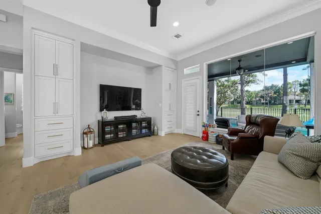 a living room with furniture a large window and a flat screen tv