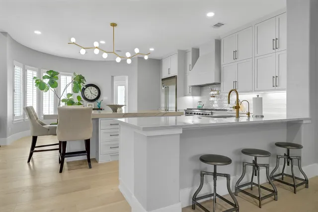 a kitchen with kitchen island granite countertop a table and chairs in it
