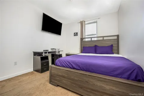a bedroom with a bed and a mirror on the dresser