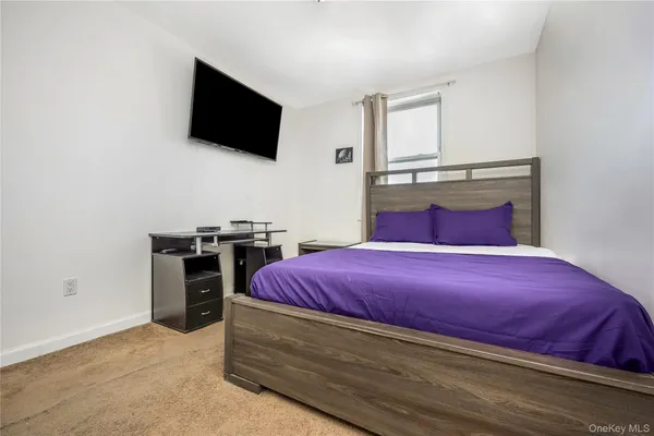 a bedroom with a bed and a mirror on the dresser