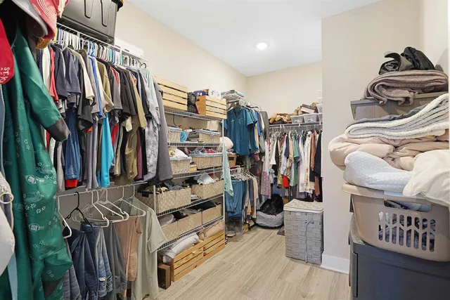 a view of walk in closet with clothes and shoes