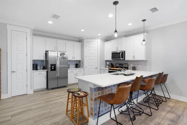 a kitchen with refrigerator cabinets dining table and chairs