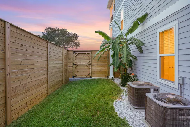 a backyard of a house with fountain plants and wooden fence
