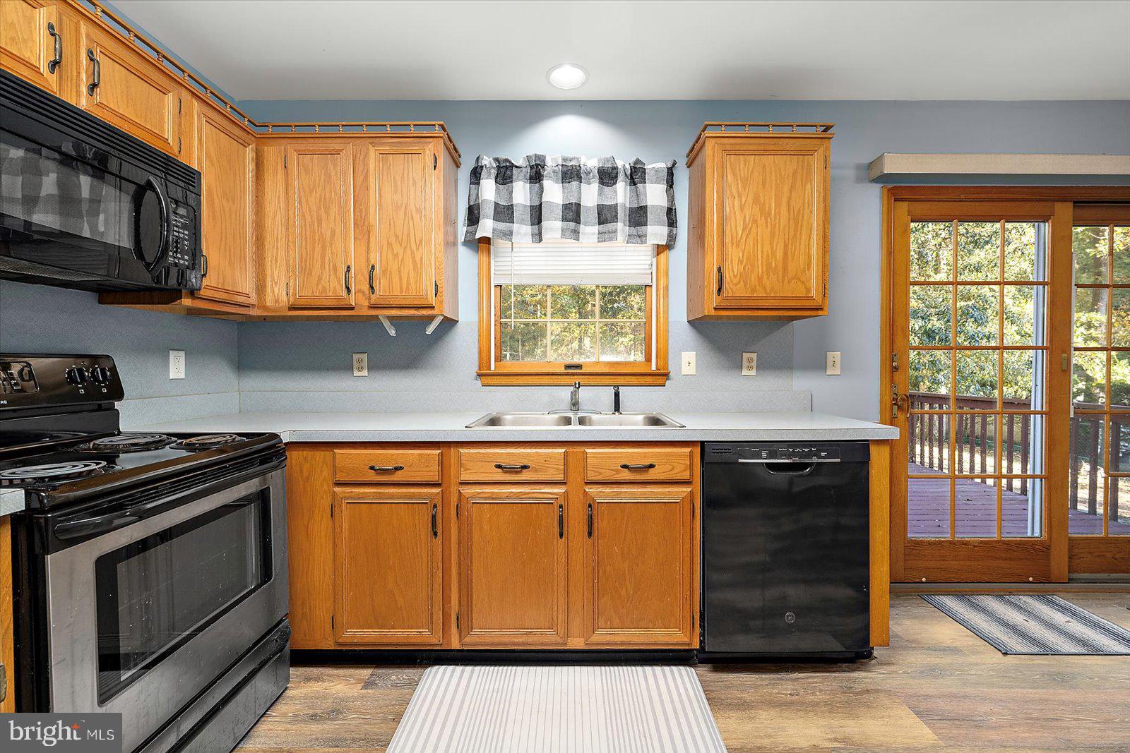 5079 Old Mill Branch Road Salisbury, MD 21801 - Photo 14 of 47 a kitchen with stainless steel appliances granite countertop a stove a sink and a microwave