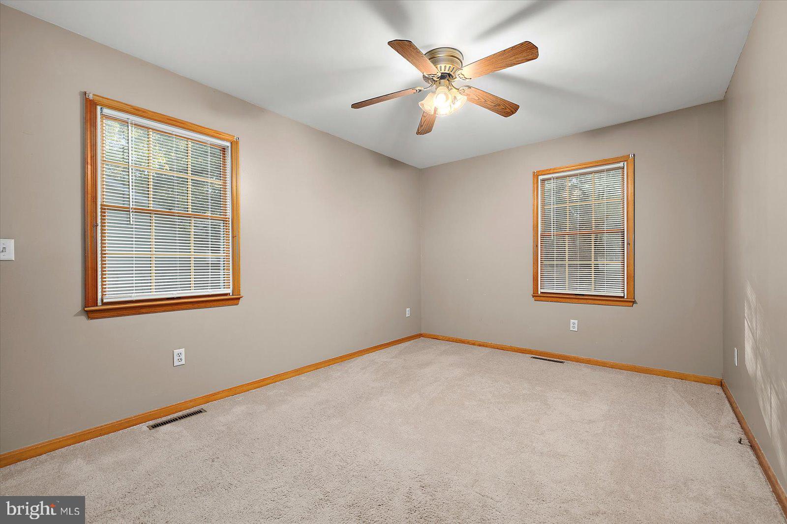 5079 Old Mill Branch Road Salisbury, MD 21801 - Photo 26 of 47 an empty room with windows and fan