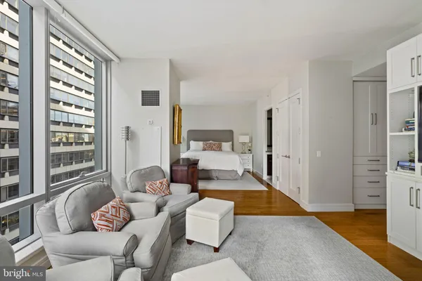 a kitchen with stainless steel appliances granite countertop a stove a refrigerator a kitchen island a dining table and chairs with wooden floor