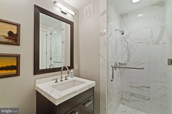 a bathroom with a granite countertop double vanity sink mirror double and shower