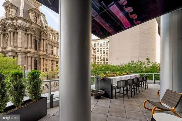a view of a roof deck with couches chairs and wooden floor