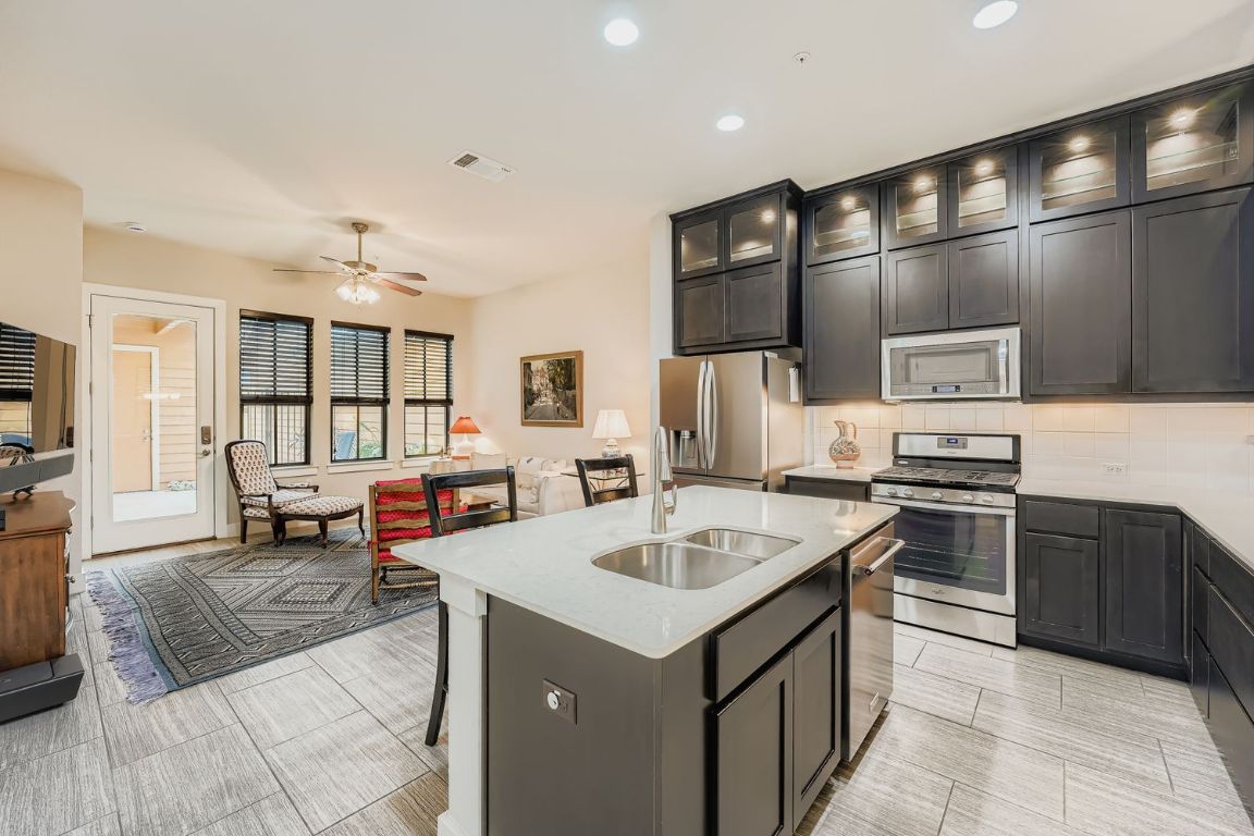 3905 Teaff Street Austin, TX 78723 - Photo 6 of 18 Kitchen featuring stainless steel appliances, lighted upper cabinets