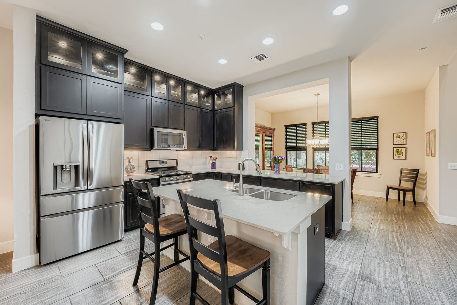 3905 Teaff Street Austin, TX 78723 - Photo 7 of 18 a kitchen with stainless steel appliances a refrigerator a stove a sink dishwasher with a dining table and chairs
