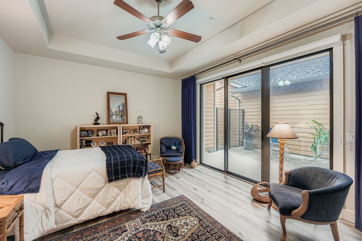 3905 Teaff Street Austin, TX 78723 - Photo 9 of 18 Main Bedroom featuring a tray ceiling, access to outside, wood finished floors, and ceiling fan