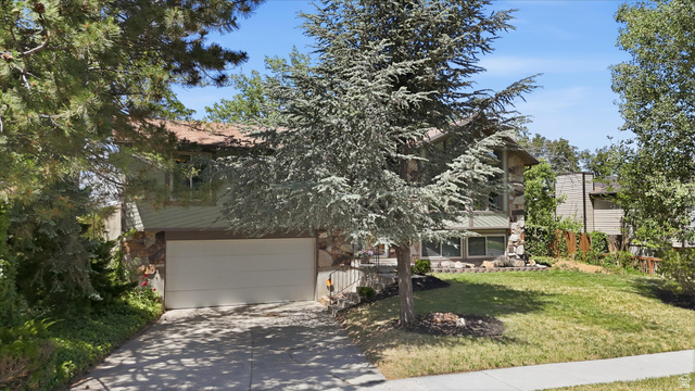 8938 Manchester Lane Sandy, UT 84093 - Photo 47 of 50 Multi-level residence featuring a two-car garage, stone facade accents, and mature landscaping