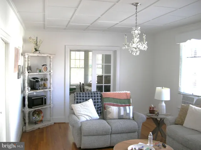 a living room with furniture a chandelier and a flat screen tv