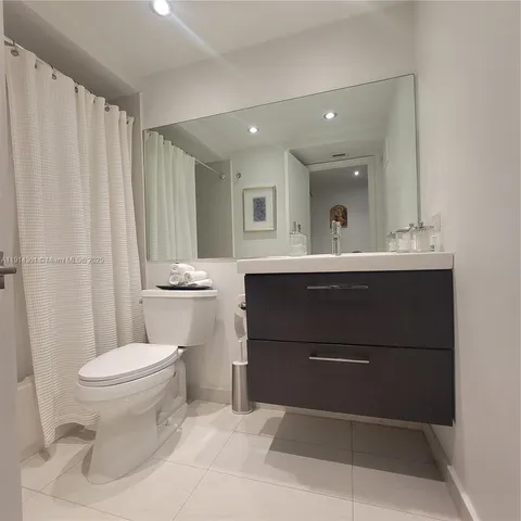 a kitchen with stainless steel appliances a sink a stove a microwave a refrigerator and cabinets