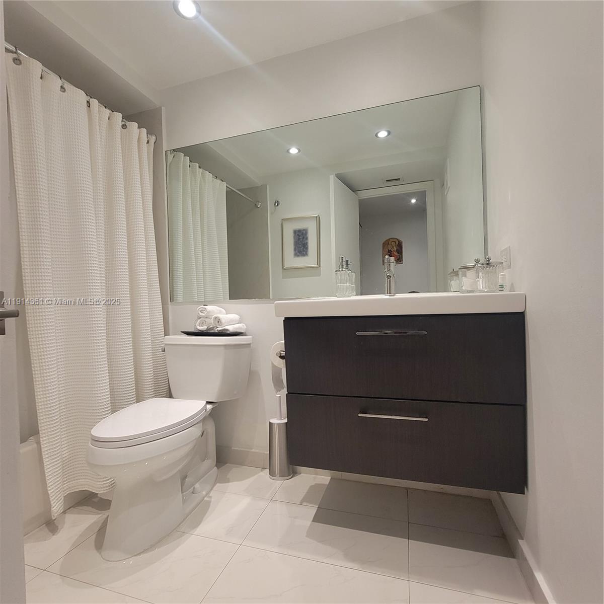 8180 Geneva Court, Unit 219 Doral, FL 33166 - Photo 12 of 19 a bathroom with a sink a toilet a mirror and shower