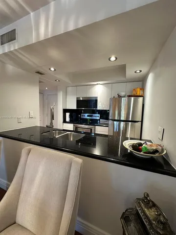 a kitchen with stainless steel appliances granite countertop a sink refrigerator stove and microwave