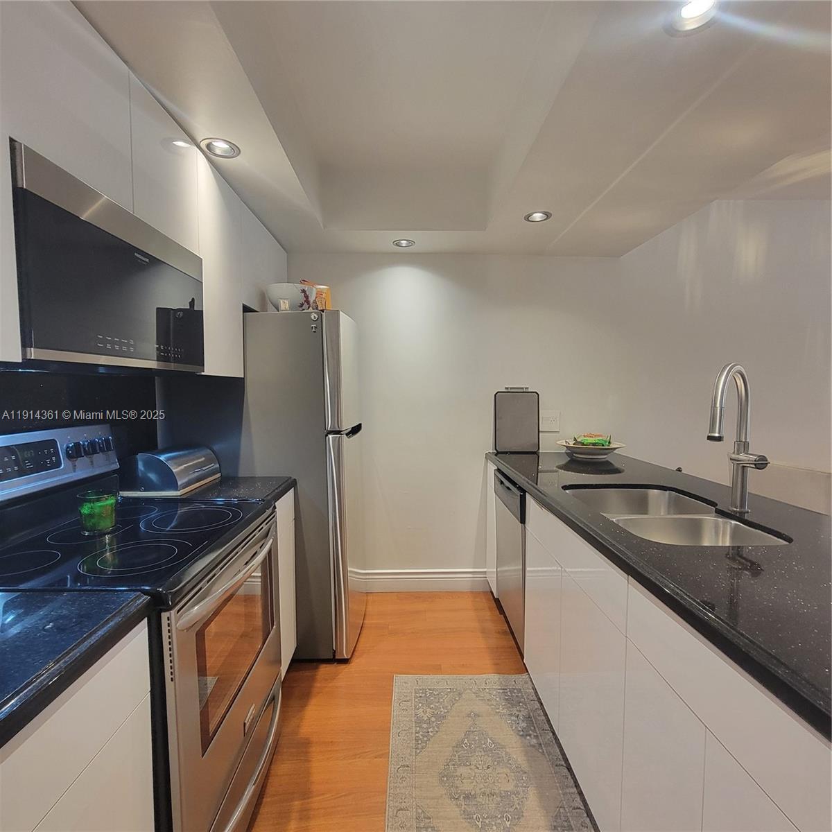 8180 Geneva Court, Unit 219 Doral, FL 33166 - Photo 5 of 19 a kitchen with stainless steel appliances granite countertop a sink stove and refrigerator