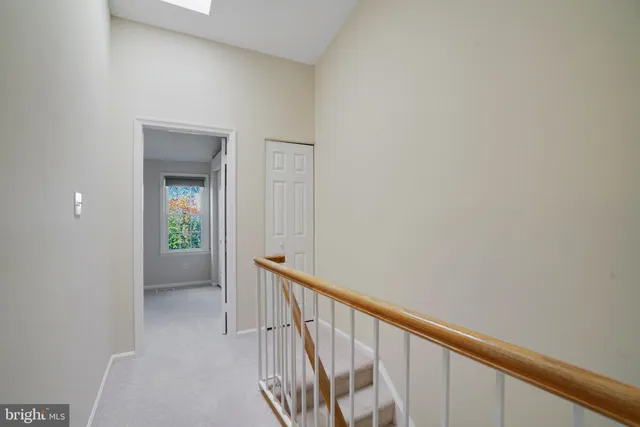 a view of a hallway with wooden floor and stairs