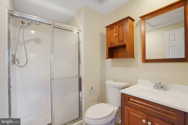 a bathroom with a granite countertop sink toilet a mirror a vanity and shower