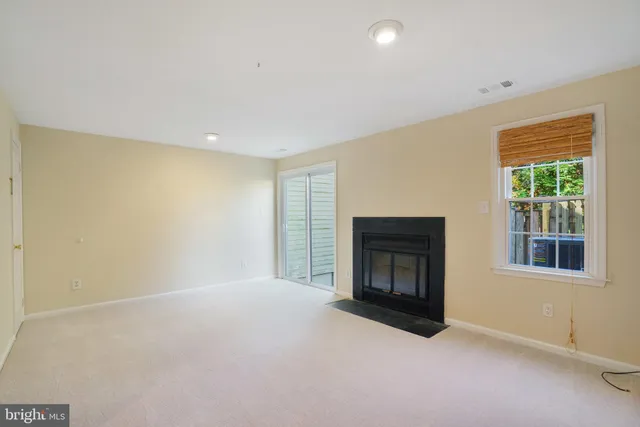 a view of empty room with wooden floor and fireplace