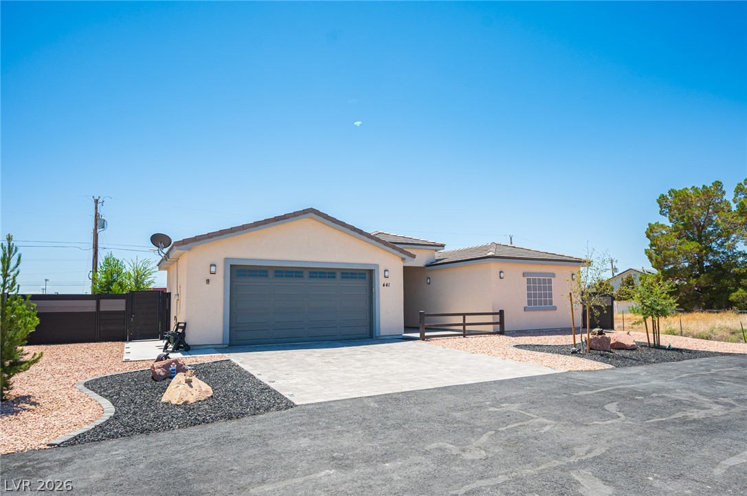 441 Belville Road Pahrump, NV 89048 - Photo 3 of 44 A well-maintained facade with a two-car garage, complemented by desert-friendly landscaping.