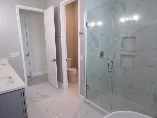 a bathroom with a granite countertop sink a toilet and a mirror