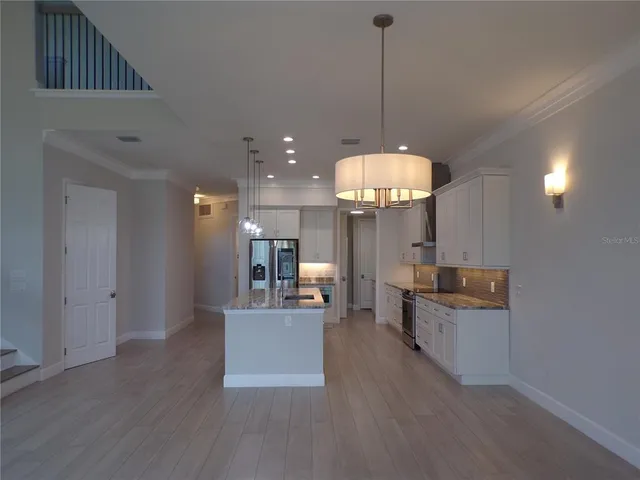 a kitchen with kitchen island a counter top stainless steel appliances and cabinets