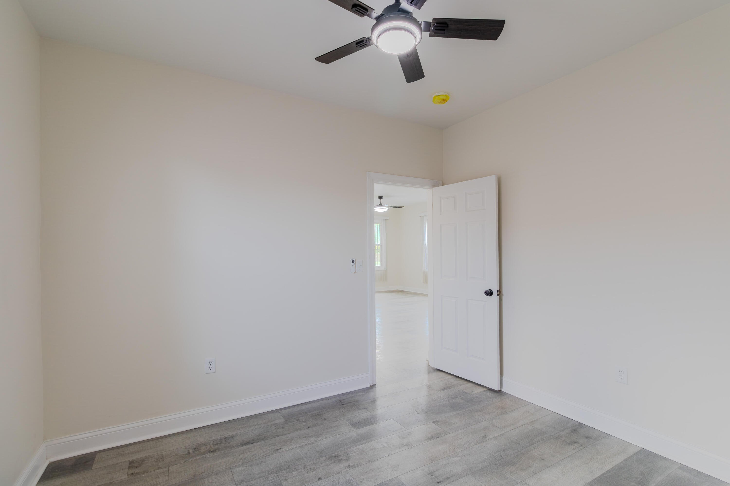 3678 Jackson Street Gary, IN 46408 - Photo 16 of 27 an empty room with a ceiling fan and wooden floor
