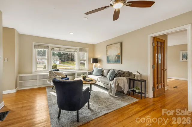 a living room with furniture and a wooden floor