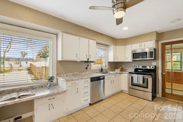 a kitchen with stainless steel appliances granite countertop a sink and cabinets