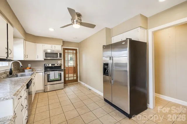 a kitchen with stainless steel appliances granite countertop a refrigerator and a stove top oven
