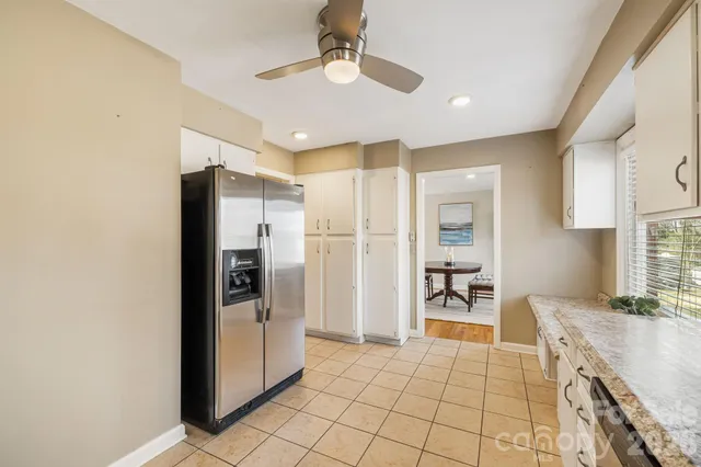 a kitchen with granite countertop a refrigerator and a stove top oven