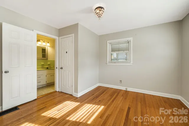 a view of a room with wooden floor and a bathroom