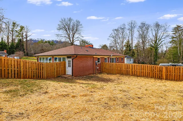 a view of a house with a wooden fence