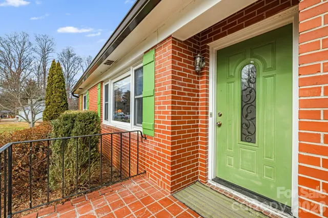 a front view of a house with a green gate