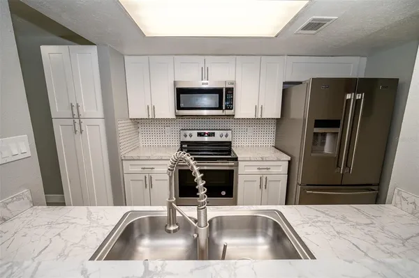 a kitchen with a sink stove and refrigerator