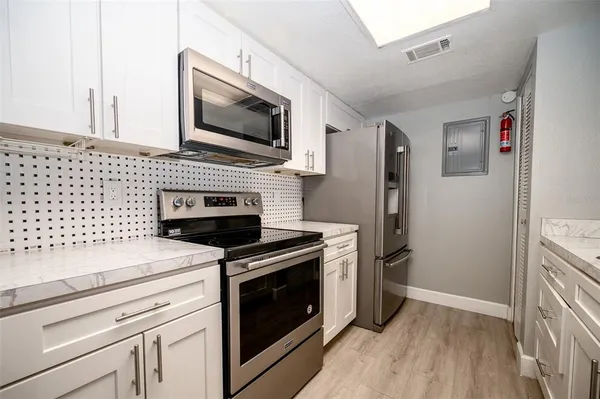 a kitchen with cabinets and steel stainless steel appliances