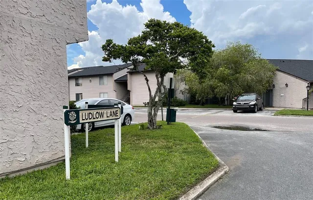 a view of a house with a big yard and potted plants