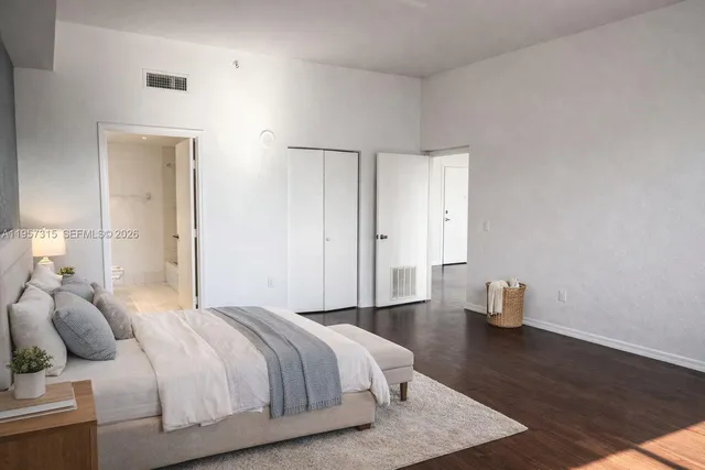 a bedroom with a bed and wooden floor