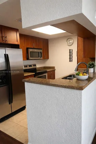 a kitchen with stainless steel appliances granite countertop a sink and a refrigerator