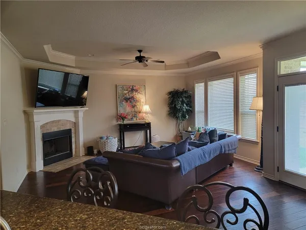 a living room with furniture a flat screen tv and a fireplace