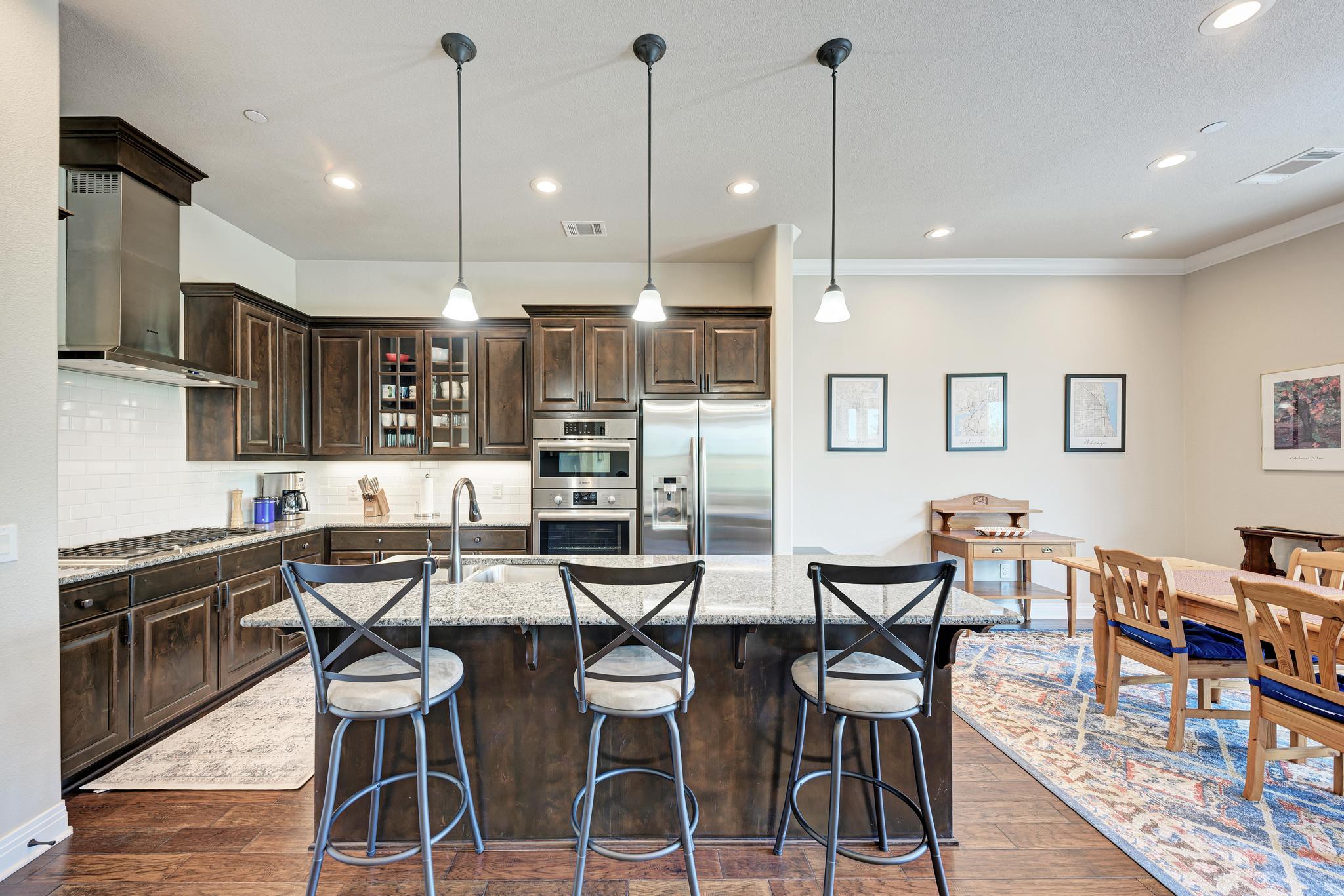 2601 North Quinlan Park Road, Unit 506 Austin, TX 78732 - Photo 13 of 39 An inviting kitchen with rich cabinetry and a central island seamlessly connects to a spacious dining area.